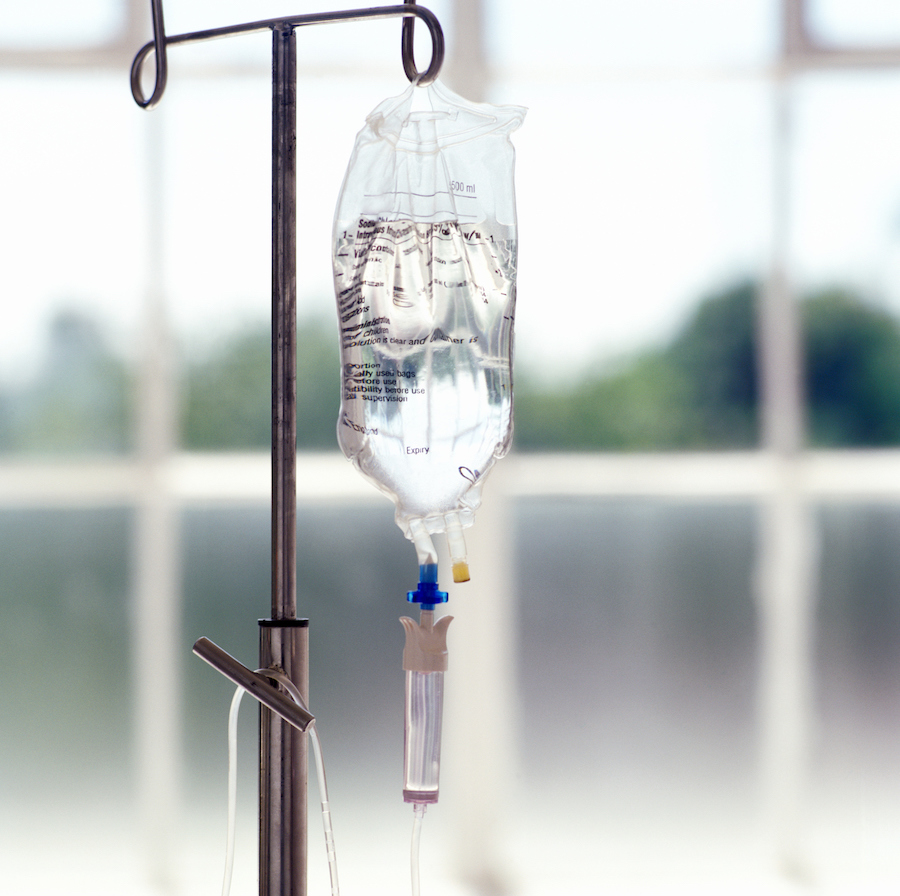 close up of a drip stand dispensing saline solution
